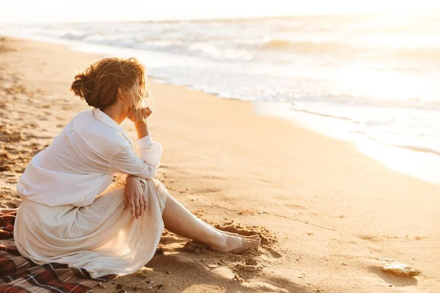 Person sitting on a Florida beach, looking out at the water