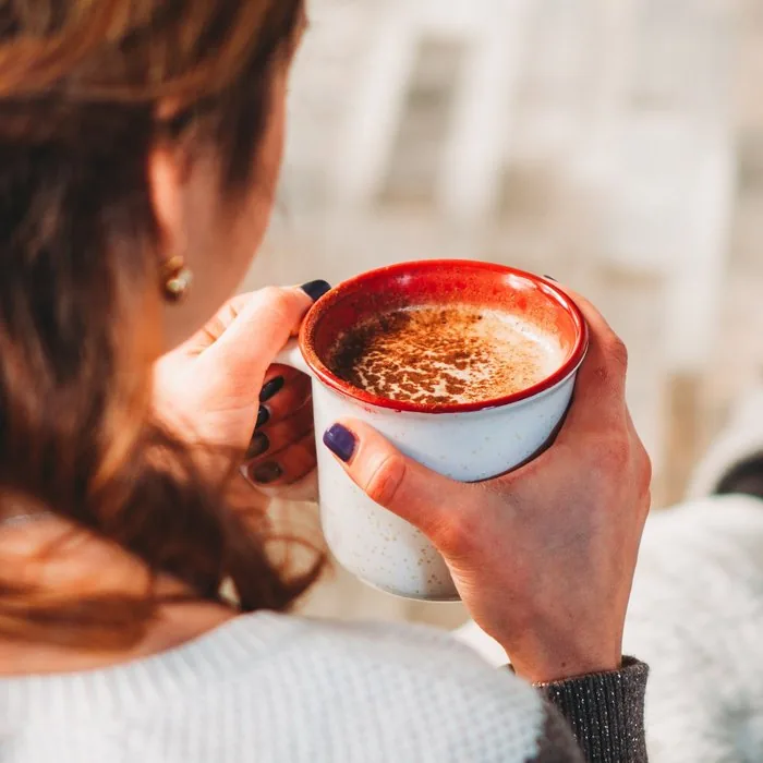 A woman holding a warm mug of coffee