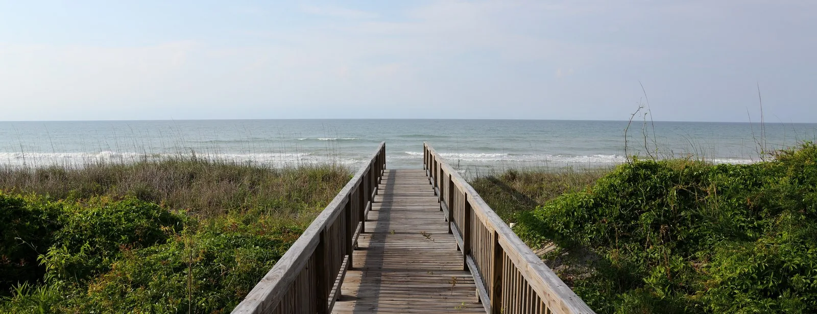 A wooden boardwalk leading to the beach