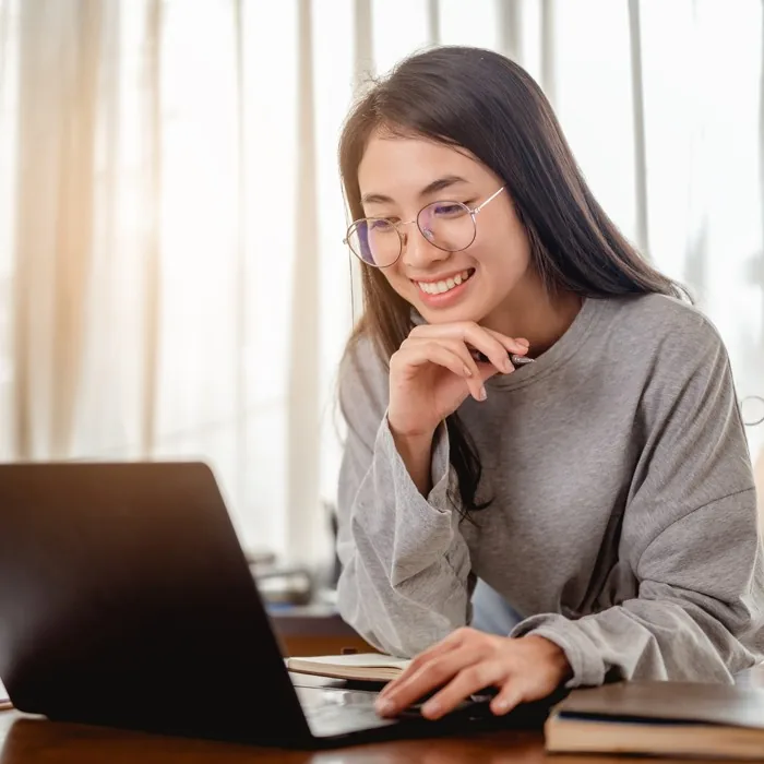 A woman smiling and reflecting at her desk